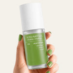 Hand holding a green skincare bottle labeled 'Noni Ampoule' against a white background